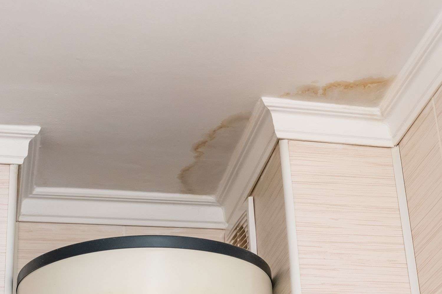 Water stains on a ceiling caused by a roof leak from previous hail damage
